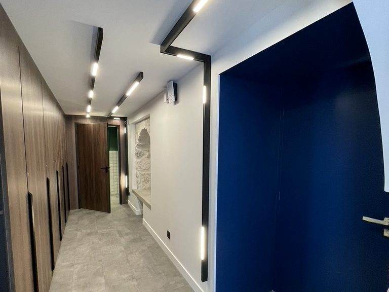 Couloir éclairé par rails lumineux encastrés