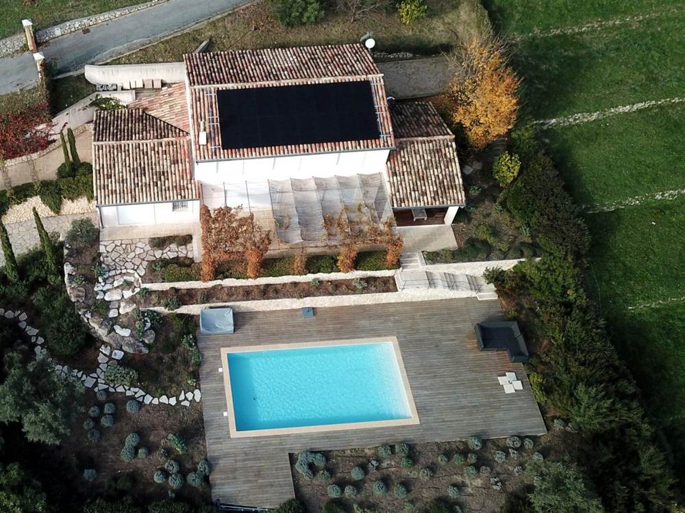 Villa avec panneaux solaires full black intégrés en toiture, vue drone