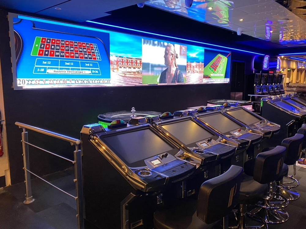 Salle de casino : roulettes électroniques et mur LED